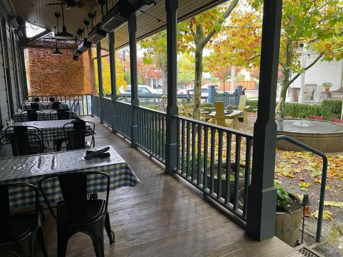 A cozy restaurant patio with checkered tables, surrounded by autumn foliage and a peaceful outdoor setting.