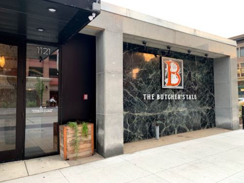 Exterior view of The Butcher's Tale restaurant, featuring a stone facade and a prominent "B" logo.