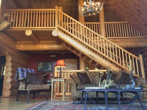 Cozy log cabin interior featuring a wooden staircase, rustic furniture, and warm lighting.