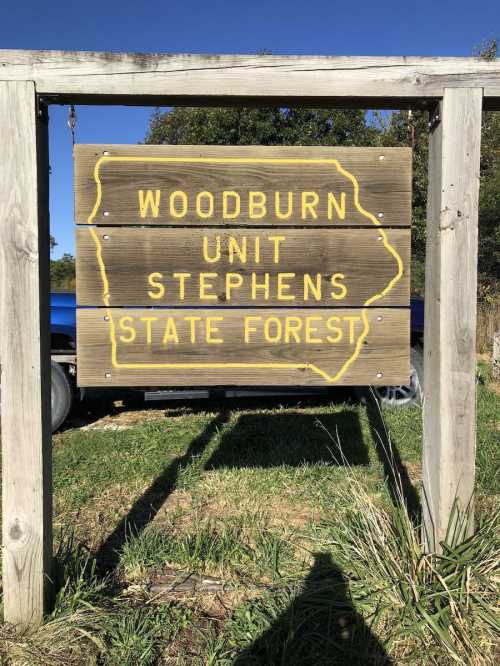 Sign for Woodburn Unit, Stephens State Forest, with a yellow outline of Iowa on a wooden background.