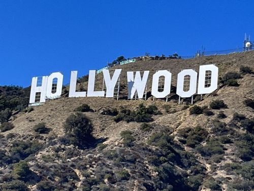 The iconic Hollywood sign on a hillside against a clear blue sky.