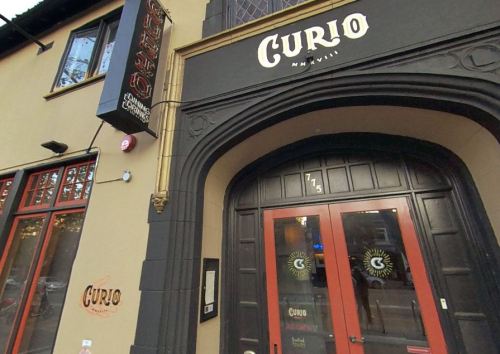 Exterior of Curio, a restaurant in Nashville, featuring a stylish entrance and signage.