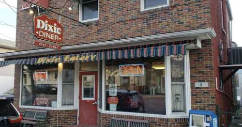 A brick diner with a striped awning and "OPEN" sign, featuring large windows and a welcoming entrance.