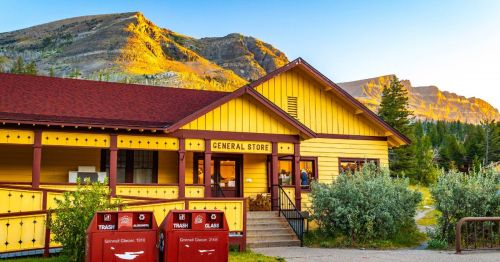 The front of the Rising Sun General Store in Glacier National Park with mountains in the background during dusk