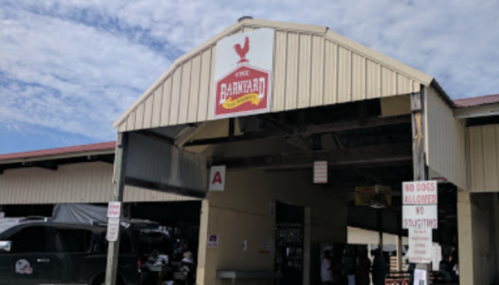 Entrance to The Barnyard, featuring a rooster logo and signs indicating no dogs allowed.