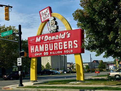 A McDonald's sign featuring "Hamburgers" and "Over 99 billion sold," with a colorful arch design.
