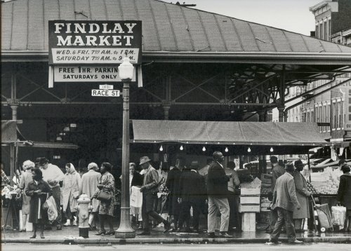 Black and white photo of Findlay Market, bustling with shoppers and vendors under a large roofed structure.