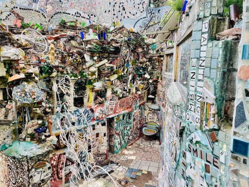 A vibrant, eclectic mosaic art installation filled with colorful tiles, sculptures, and creative designs throughout.