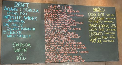 Chalkboard menu listing draft beers, wines, and sangria options at a bar or restaurant.