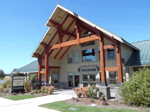 Exterior view of La Pine City Hall, featuring a modern design with wooden beams and a welcoming entrance.