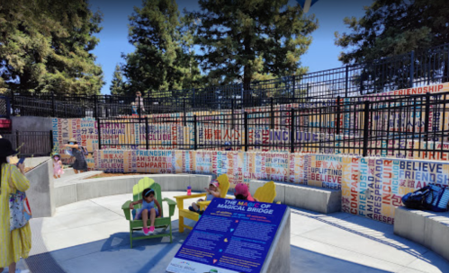 A colorful park area with benches and a sign, surrounded by trees and featuring words like "friendship" and "believe."