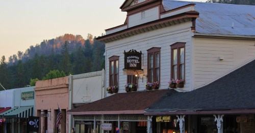 A historic hotel and other buildings line the street in the downtown area of Mariposa, California.