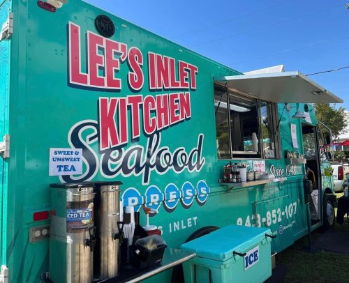 A vibrant food truck named "Lee's Inlet Kitchen" serving seafood and sweet tea, with a teal exterior and menu signage.