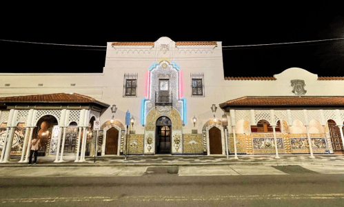 A beautifully illuminated historic building with intricate tile work and architectural details at night.