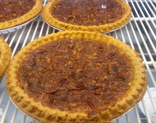 Two pecan pies cooling on a wire rack, showcasing a golden crust and a rich, nut-filled filling.