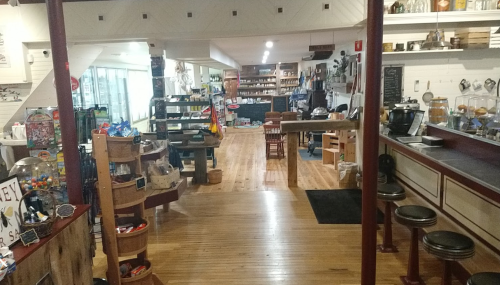 A cozy store interior with wooden floors, shelves filled with products, and a welcoming atmosphere.