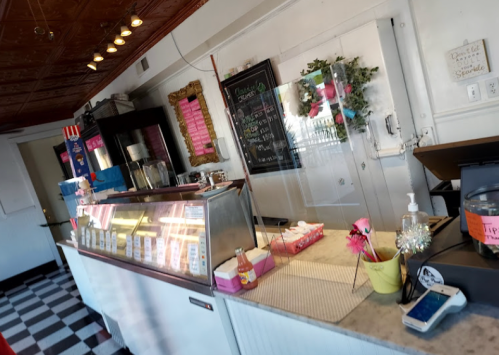 Interior of an ice cream shop featuring a service counter, menu board, and decorative elements.