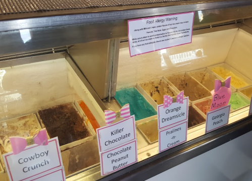 Ice cream display with various flavors labeled, including Cowboy Crunch, Killer Chocolate, and Blue Moon.