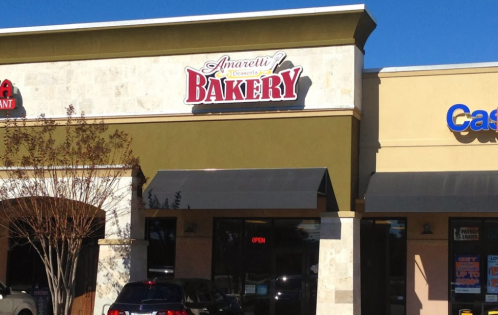 Sign for "Amaretti Desserts Bakery" on a storefront, with an "OPEN" sign visible in the window.