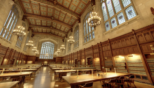 A grand library interior with high ceilings, chandeliers, wooden shelves, and long tables for studying.
