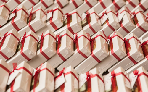 A close-up of neatly arranged gift boxes tied with red ribbons, creating a visually appealing pattern.