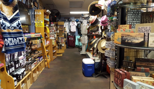 A colorful store aisle filled with various merchandise, including hats, decor, and clothing, with shelves on both sides.
