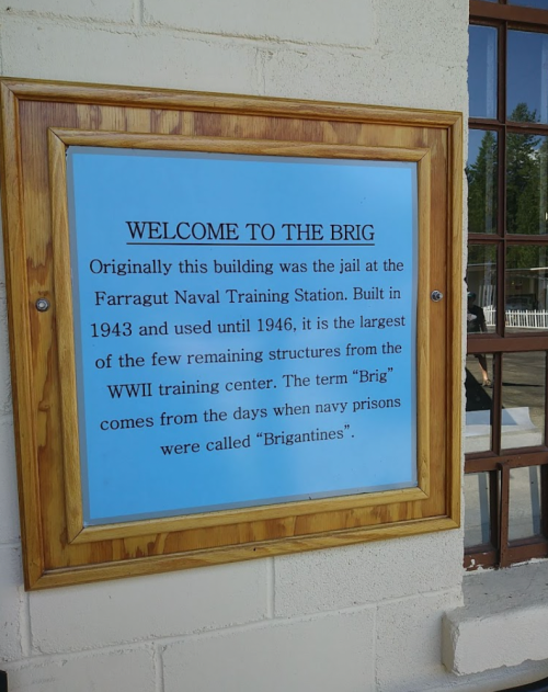 Sign on a building detailing its history as the jail at Farragut Naval Training Station, built in 1943 and used until 1946.