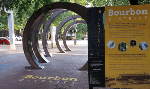 A circular sculpture in the Bourbon District with an informational sign about the area and its history.