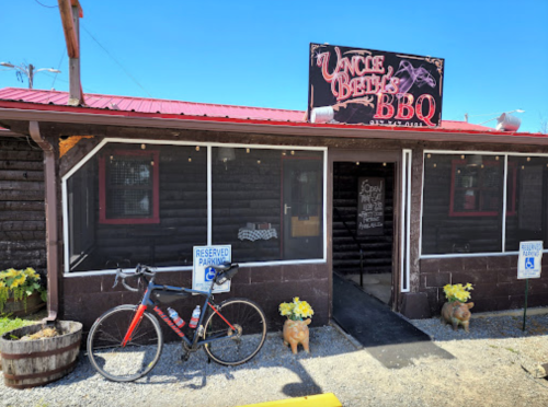 Exterior of Uncle Beth's BBQ, featuring a bike parked outside and a sign indicating it's open for business.