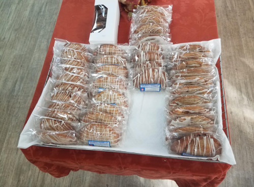 A tray of individually wrapped pastries arranged neatly on a table, with a few decorative items in the background.