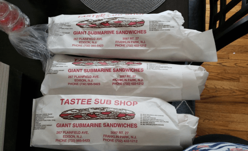 Three wrapped submarine sandwiches from Tastee Sub Shop, labeled with the shop's address and contact information.