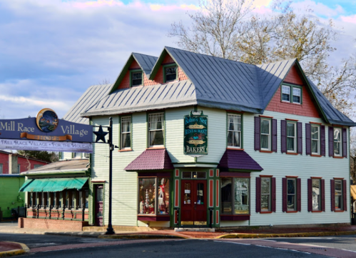 Historic building in Mill Race Village featuring a bakery and restaurant, with colorful exterior and inviting signage.