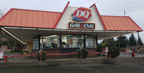 A Dairy Queen Grill & Chill restaurant with a red roof and signage, surrounded by caution tape.