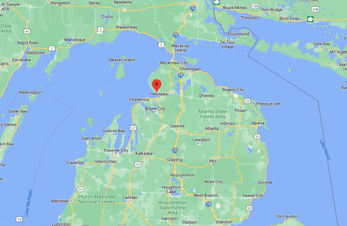 Map showing the northern part of Michigan, highlighting the area around Petoskey with nearby lakes and towns.