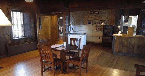 Cozy interior of a café and gift shop with wooden furniture and warm lighting.