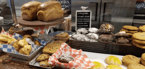 A display of various baked goods, including loaves of bread, cookies, and pastries on a counter.