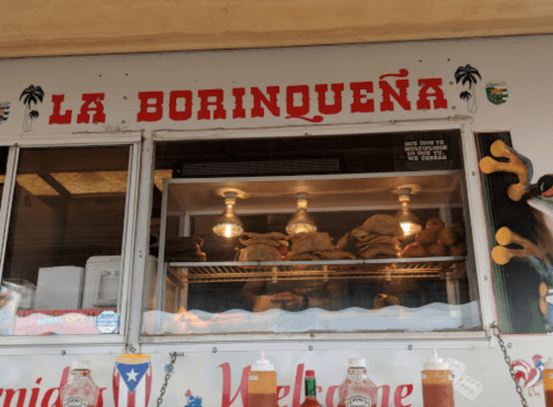 Food truck window displaying various food items with the sign "La Borinqueña" above.