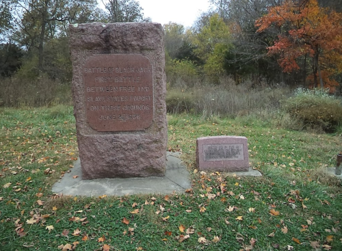 Monument commemorating the Battle of Black Jack, June 2, 1856, surrounded by trees and grass in a rural setting.