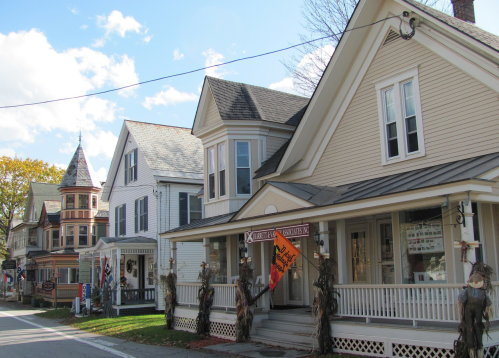 Charming row of historic houses with decorative porches and autumn decorations under a blue sky.
