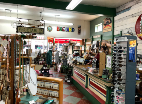 A cozy market interior with a wooden counter, shelves of goods, and colorful signs, creating a welcoming atmosphere.