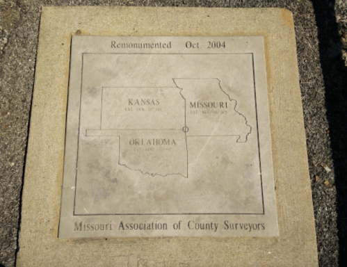 Engraved stone plaque showing a map of Kansas, Missouri, and Oklahoma, marked with "Remonumented Oct. 2004."