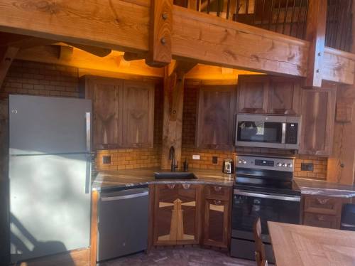 A rustic kitchen with wooden cabinets, stainless steel appliances, and a warm, inviting atmosphere.