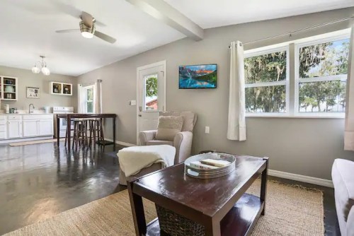 Cozy living space with a kitchen, dining area, and large windows showcasing natural light and outdoor views.