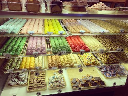 A display case filled with colorful macarons and assorted pastries, arranged neatly in rows.