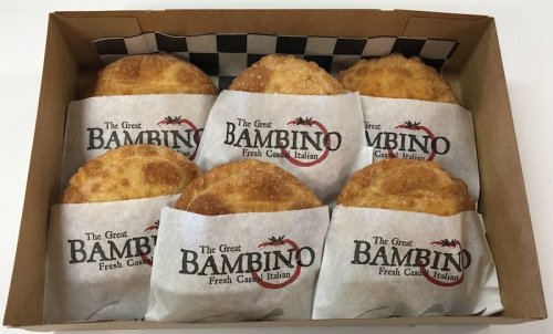A box containing six golden-brown, crispy pastries wrapped in branded paper from The Great Bambino.