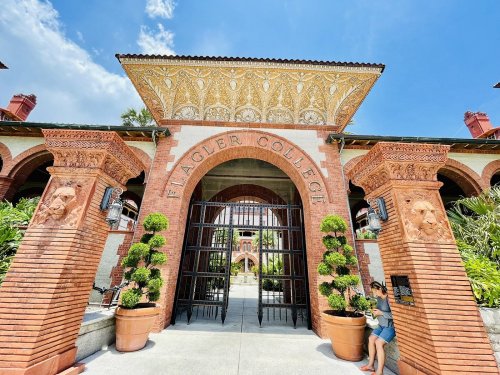 Entrance to Flagler College featuring ornate brickwork, decorative arches, and lush greenery.