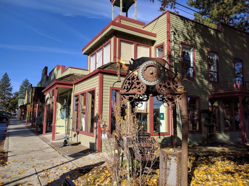 A colorful, vintage-style building with large windows and decorative elements, surrounded by autumn leaves.