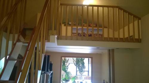Interior view of a home featuring a wooden staircase and a loft area with plants and decor visible.