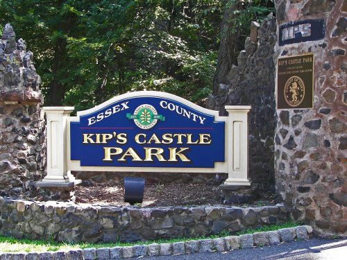 Sign for Kip's Castle Park in Essex County, featuring stonework and greenery in the background.
