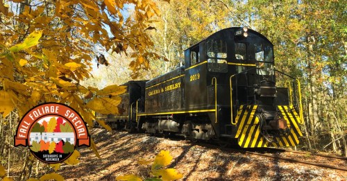 A vintage black train surrounded by autumn leaves, with a logo for the Fall Foliage Special in the corner.